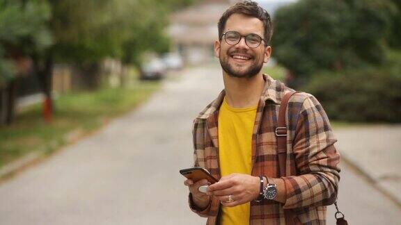 年轻的成年男性微笑着在电话里输入信息