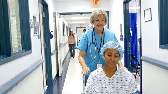 高级护士在医院走廊推病人