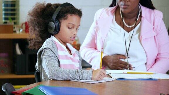 学生写作时戴着降噪耳机