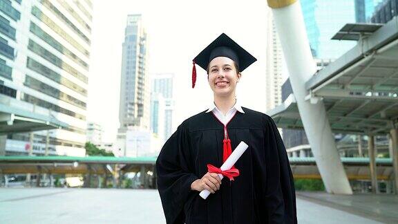 美丽的微笑毕业的学生女孩年轻的女人走在帽子长袍走着拿着文凭