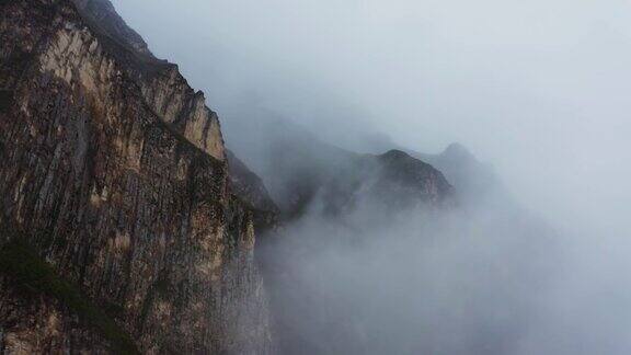 从四轴飞行器上透过云层看到陡峭的岩石山脉