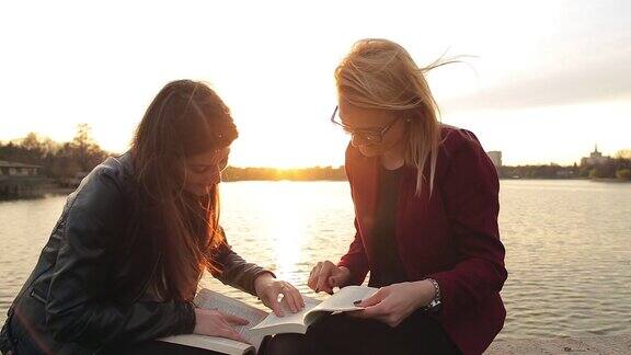 两个漂亮的年轻女人在公园里看书