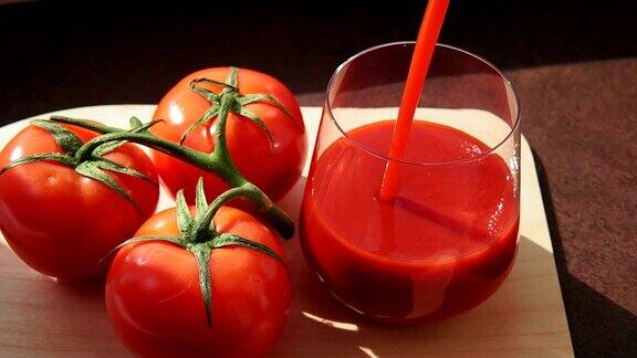 美味的番茄汁在一个成熟的红色西红柿将番茄汁倒入玻璃杯中