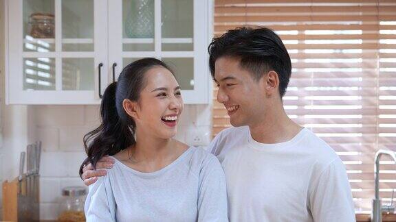 一对幸福的亚洲夫妇对着镜头拥抱微笑