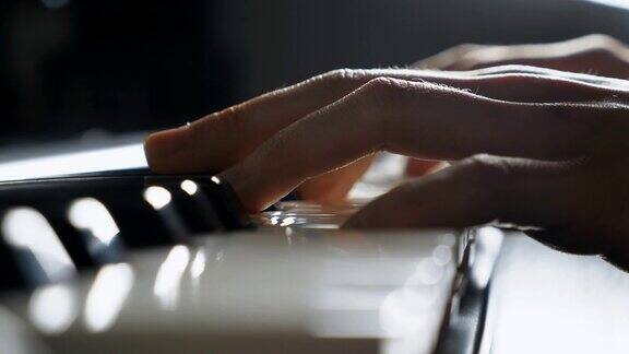 闭合钢琴家的手指按在黑白钢琴键人之手奏音乐独奏曲在合成器演奏的男性音乐家的手臂慢动作孤立镜头