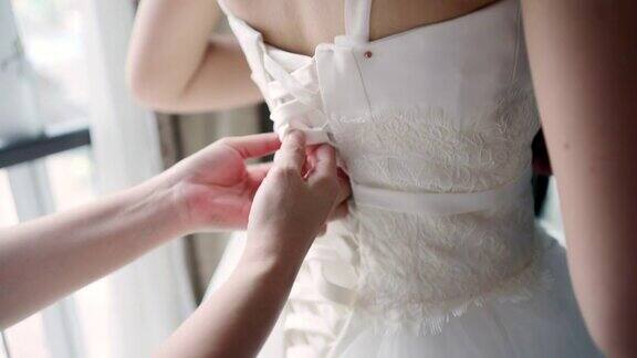 裁缝师正在测量身体的尺寸然后试穿婚纱