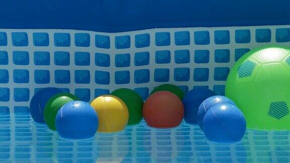 不同颜色的球漂浮在一个夏天的小水池里