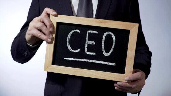 CEO写在黑板上身着经典西装的男人举着牌子商业战略