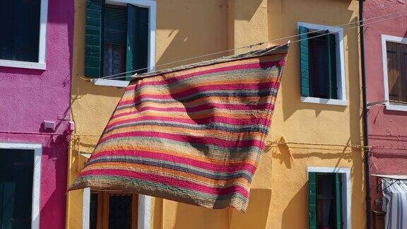 Burano威尼斯意大利街道上有五颜六色的房子和彩色的桌布铺开晾干