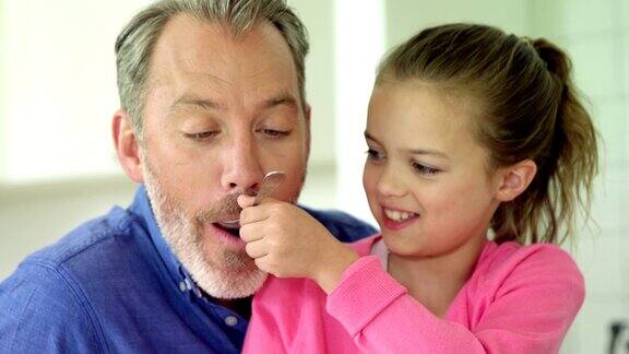 女儿用勺子喂父亲