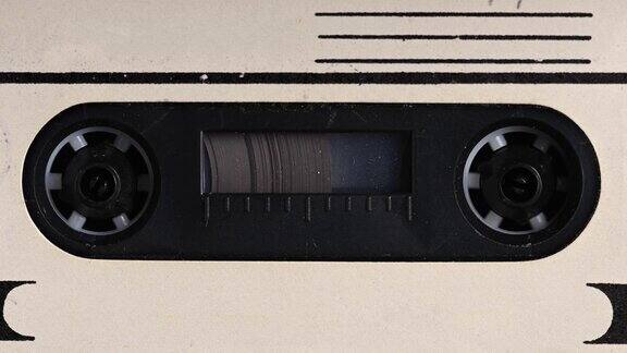 录音机正在播放录音带特写镜头老式磁带在一盘空白标签磁带上旋转用于在复古盒式磁带播放机中录制声音记录的对话