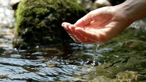 慢动作:用手在纯净的山泉中舀淡水