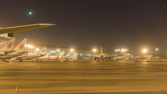 间隔拍摄北京首都国际机场夜间航站楼飞机起降