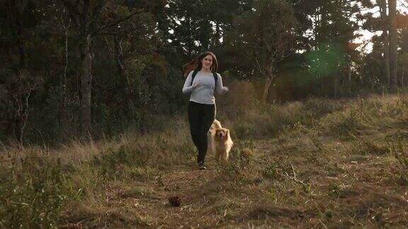 一个女人带着她的狗在大自然中奔跑
