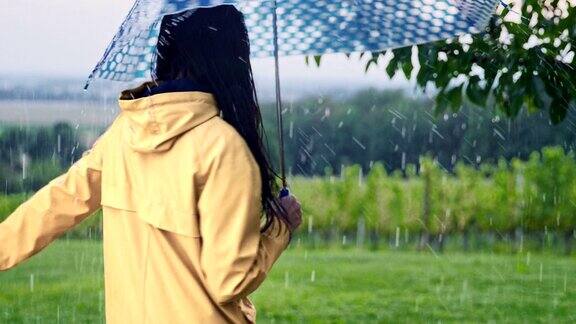 SLOMO年轻女子在雨中打伞玩纺纱