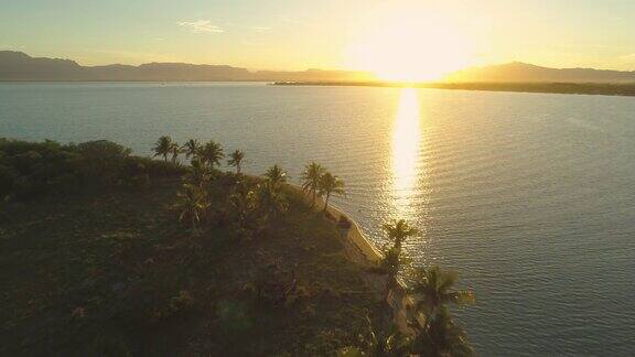 空中摄影:日出时在宁静的热带岛屿空旷的沙滩上飞翔
