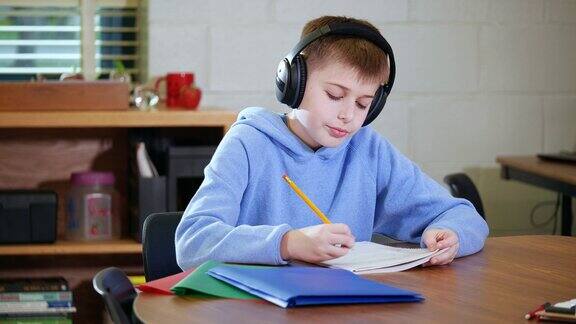 学生写作时戴着降噪耳机