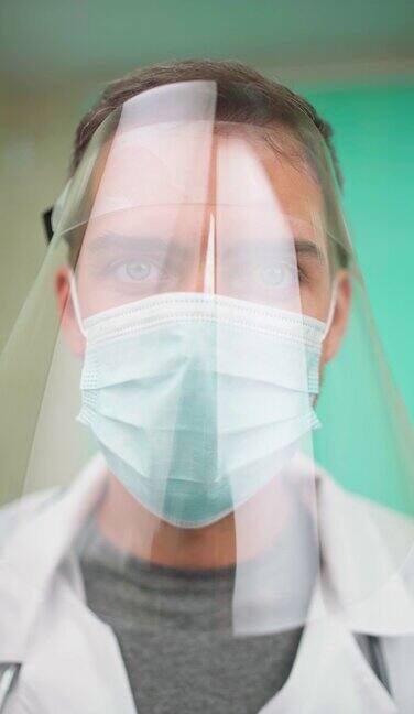冠状病毒医生在防护面罩和口罩看着相机