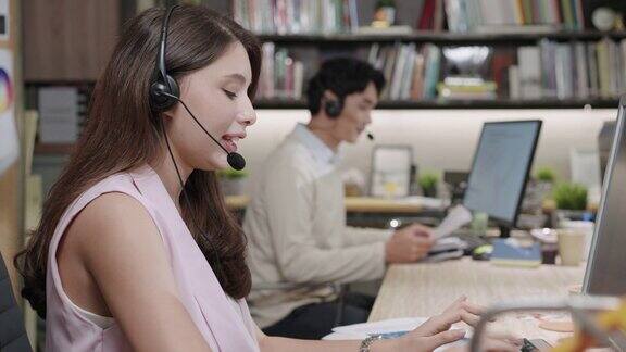 亚洲呼叫中心代理在工作站以最专业的方式与客户沟通