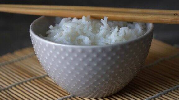 米饭放在瓷碗里配上日本筷子酱油放在灰色的石头桌子上