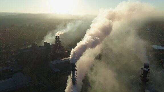 日落时工业厂房冒烟的烟囱