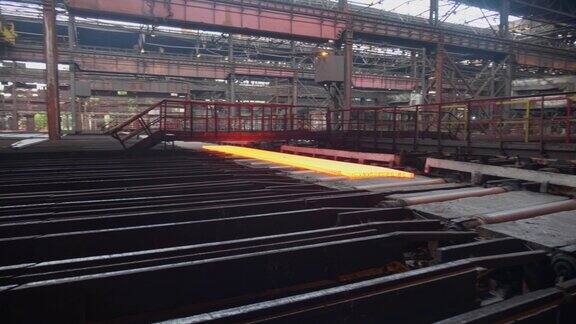 冶金工厂的金属生产过程一个分开的钢坯沿着传送带移动冶金工厂滚动商店经营理念现代钢铁生产技术