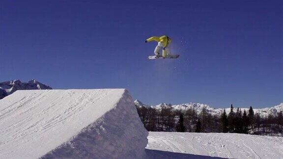 慢动作:滑雪者在雪地公园跳过一个踢球者