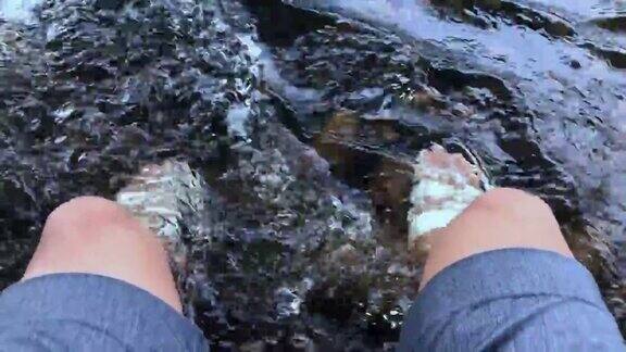 人的脚浸在河里快乐地流动着