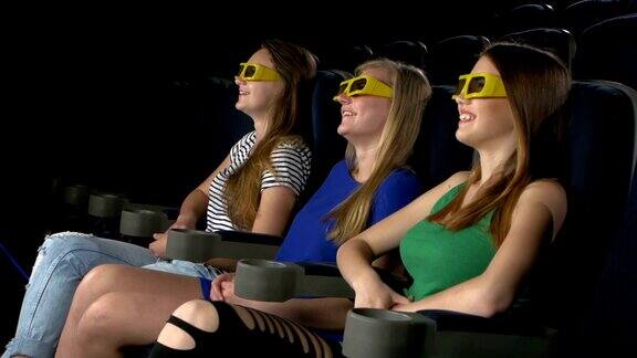 年轻的朋友在电影院看电影戴着3d眼镜