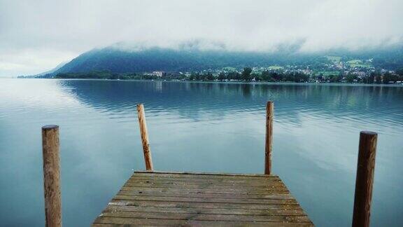 在奥地利阿尔卑斯山风景如画的高山湖泊上的木制码头Steaducam拍摄