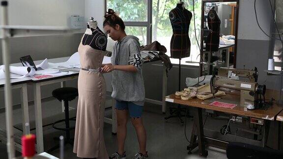 亚洲华裔女性时装大学生测量和工作服装项目在学院工作坊