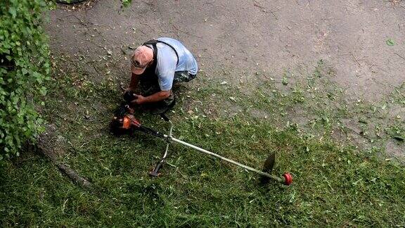 一名男子将汽油倒进割草机