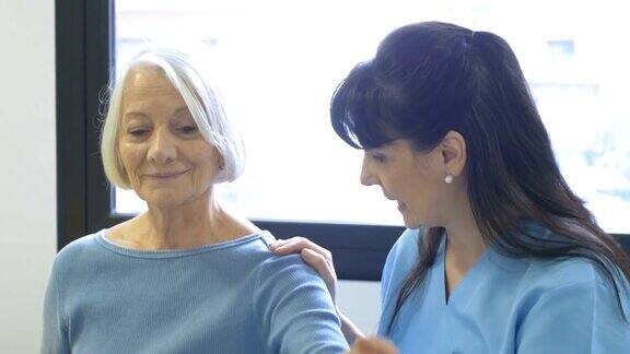 护士协助老年妇女进行手部锻炼