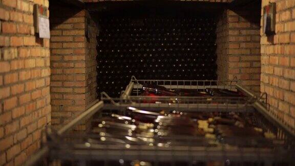 意大利古老的酒窖在酒窖的架子上和金属篮子里没有标签的酒瓶黄色的光线照射在地窖里4k(UHD