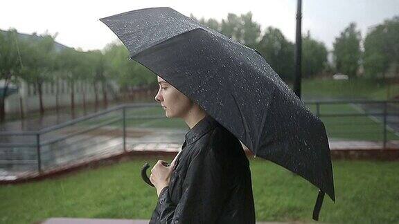 孤独悲伤的女人站在大雨下的街道上