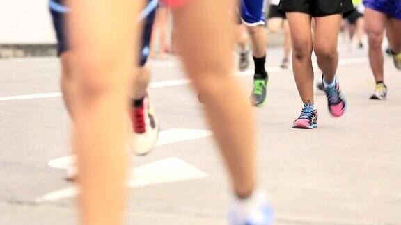 马拉松赛跑人们脚踩在城市的道路上