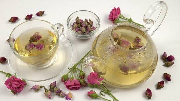 茶壶和茶杯花茶从粉红色的干玫瑰花蕾