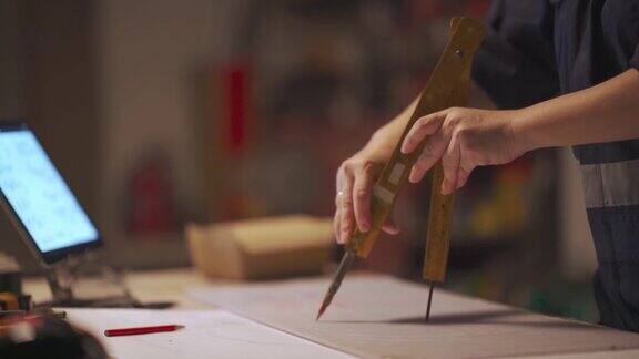亚洲华裔女木匠在她的工作室中用圆规画画