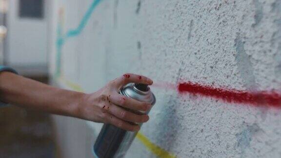 涂鸦艺术家的手在喷墙