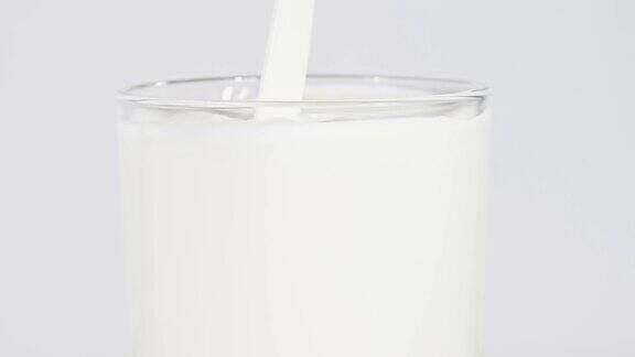 近距离倒新鲜牛奶在玻璃上的白色
