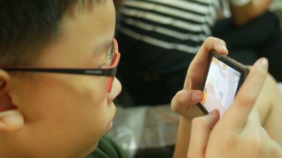 亚洲男孩用智能手机玩数字游戏