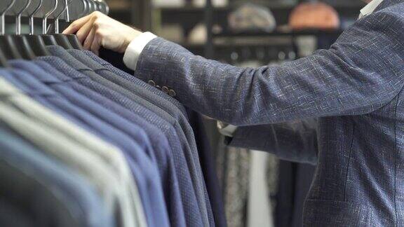 一个特写的客户看通过经典的男性西装在展示的男装商务服装店品牌男装精品