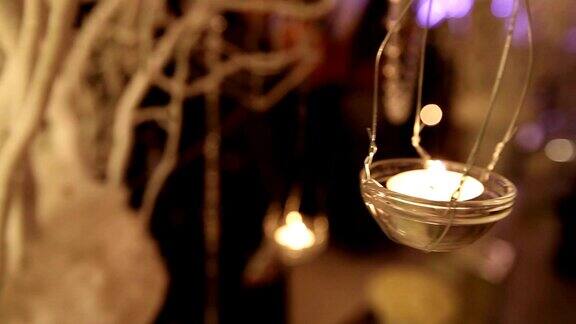 宴会桌上的玻璃烛台装饰烛台浅景深模糊不清的人在餐厅跳舞的剪影餐厅内部新年圣诞节婚礼
