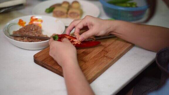 女人在客厅里用菜刀切和用手清洗辣椒