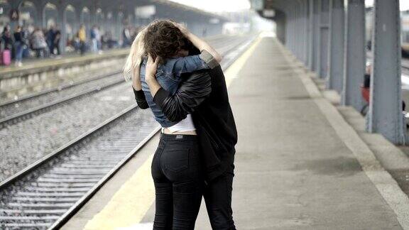 可爱的金发女孩寻找男朋友然后亲吻他显示她的爱在火车站