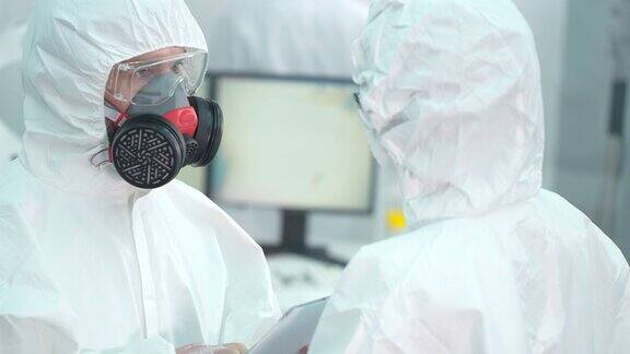 科学家们穿着防护服在实验室里交谈