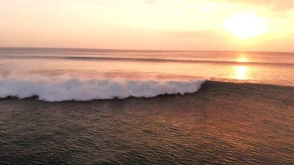 鸟瞰图与海洋和波浪在巴厘岛温暖的日落