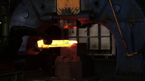 铁匠工厂用工业锻压机锻造大型铁坯机器人工作的特写金属锻造厂的技术设备大型机器铁匠移动和加热金属和准备管道的轨道的blacksm