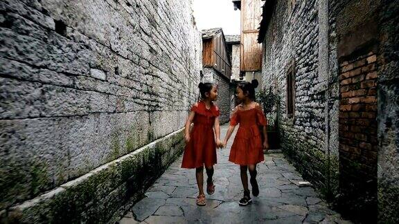 中国贵州安顺小女孩们在一条老胡同里散步