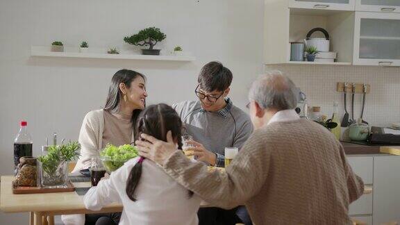 远景:快乐的亚洲家庭一起享用早餐快乐的父母爷爷和可爱的女儿在家里的餐桌上一起享用早餐美妙的时刻家庭